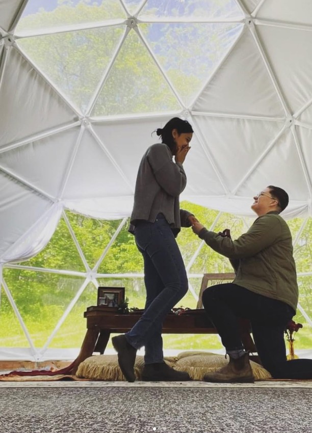 A couple celebrating a proposal at Rooted Timbers